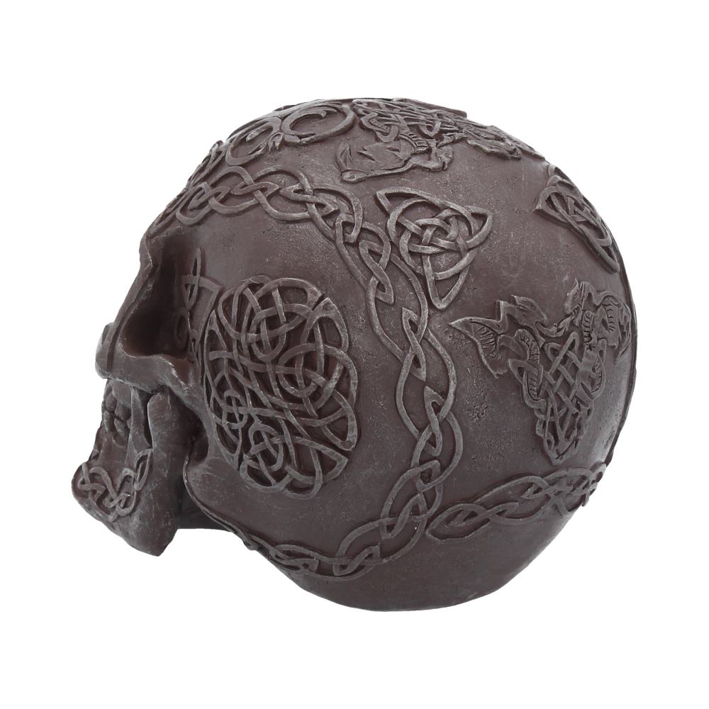 An angled view showing the left back side of a iron looking skull. Very intricate designs are imprinted all over the skull with a few gaps in between them. The skull itself under the designs is smooth to look at.