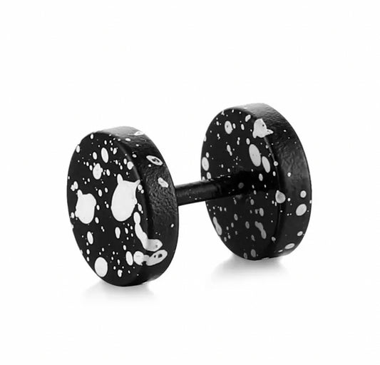 A black fake plug style earring is featured on a white background. This item has white splatters dotted all over it giving it a cool fresh look.