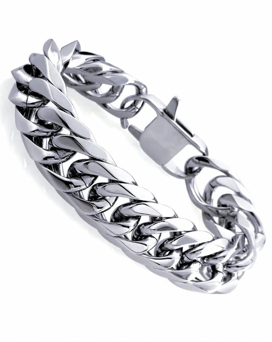 On a white background is a silver coloured chunky bracelet. It is made up of links all around it and has a sturdy looking clasp to fasten it. This item is solid to look at and is shiny in appearance. 