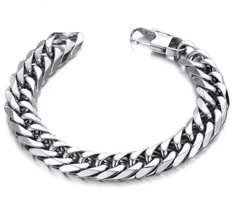 A very chunky looking link chain bracelet sits on a white background. The item is not fastened but you can see the clasp that links it together. It is weighty in the hand.