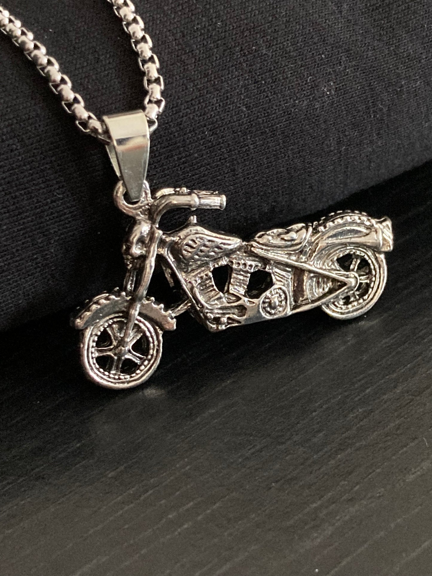 A front view showing a incredibly detailed motorcylce pendant. The markings are stunning and so intricate in design. The whole necklace is silver in colour and it is a chunky solid item to hold and wear.