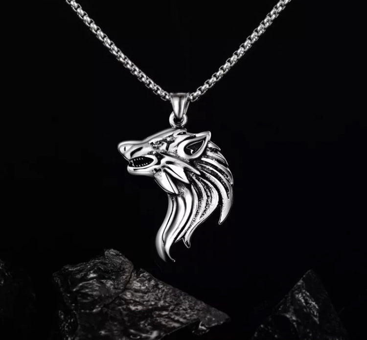 Hanging above a black rock is a wolf head pendant. A sideways view of the head shows the animal to be snarling in a ferocious manner. With its fur running down the back of its head the detailing on this silver stainless steel item is exquisite. 