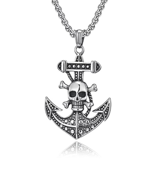 A anchor pendant with a skull and crossbones on the shaft of it sits on a white background. There is a chain attached to it and both are a shiny silver colour. This is a Chunky solid piece and is weighty in the hand to hold.