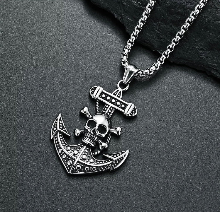 An angled anchor pendant sits upon a grey background. Attached to a sturdy looking chain this item also features a skull and crossbones on the anchor itself and the whole thing is beautifully detailed.