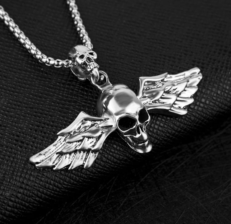 A skull pendant with wings coming out either side of it feature  here. This is solid and chunky and is silver in colour. The skull has detailed features including hollowed out eye sockets and a grinning mouth. 