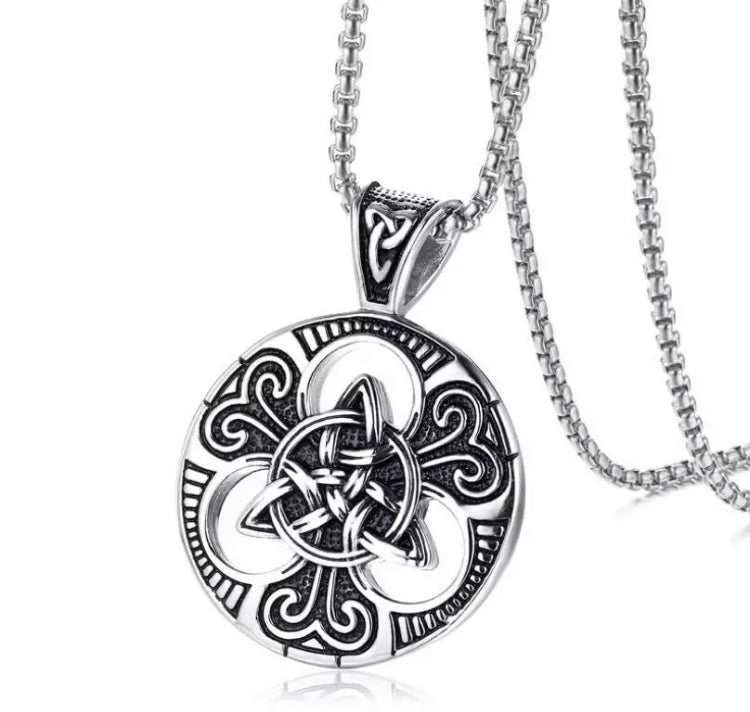 A necklace with round pendant in on a white background. Silver in colour the chain is sturdy looking and the pendant is a triqueta interlocking triangular design that is intricate in detail.