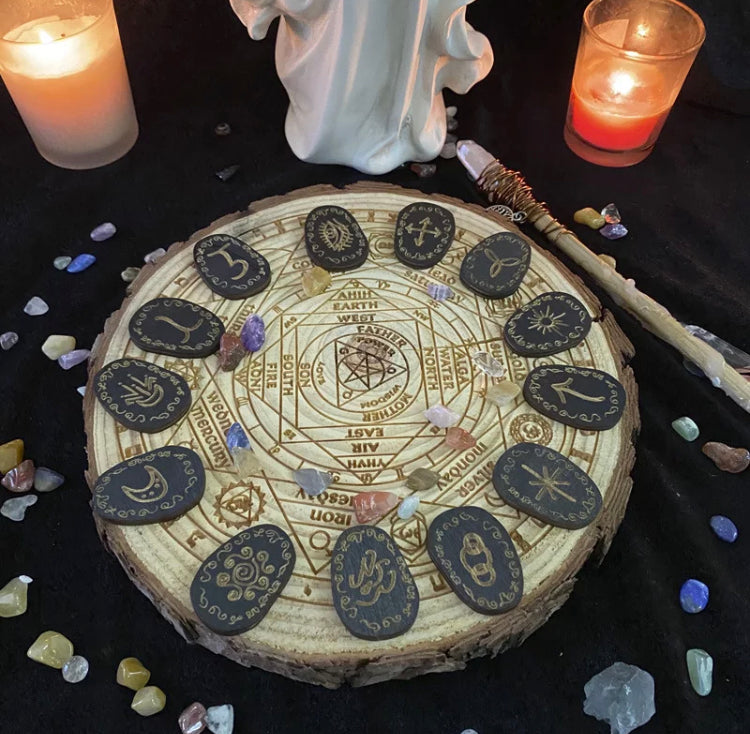 A carved round piece of wood holds 13 engraved wooden runes which are stunning in detail. The background shows candles and stones which set the scene perfectly. The runes are not perfect circles but maybe more oval in shape instead.