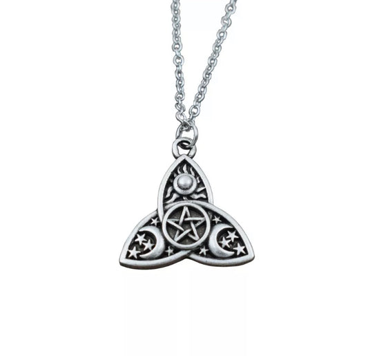 On a white background hangs a silver coloured pendant in the shape of a triple moon design. This has moons and stars engravevd onto the main shape with a small pentagram in the centre of it.