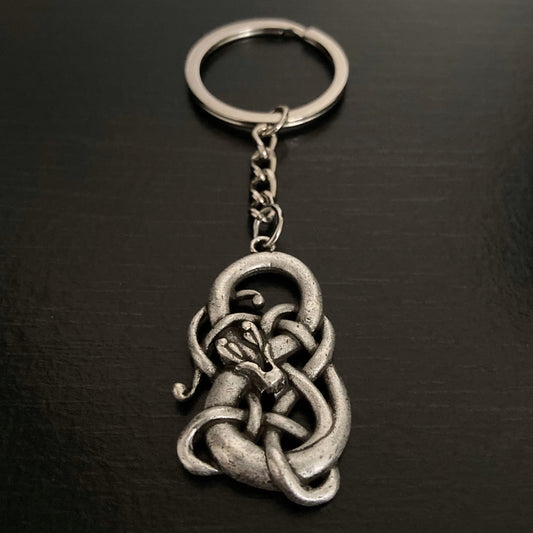 A silver coloured keyring with a infinity symbol hanging by a chain from the ring part. There is a snake wrapped around the infinity symbol.