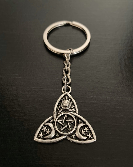 A silver coloured ring for keys is attached to a small chain and then a triple moon design featuring a small pentagram in a circle in the centre of the design. 