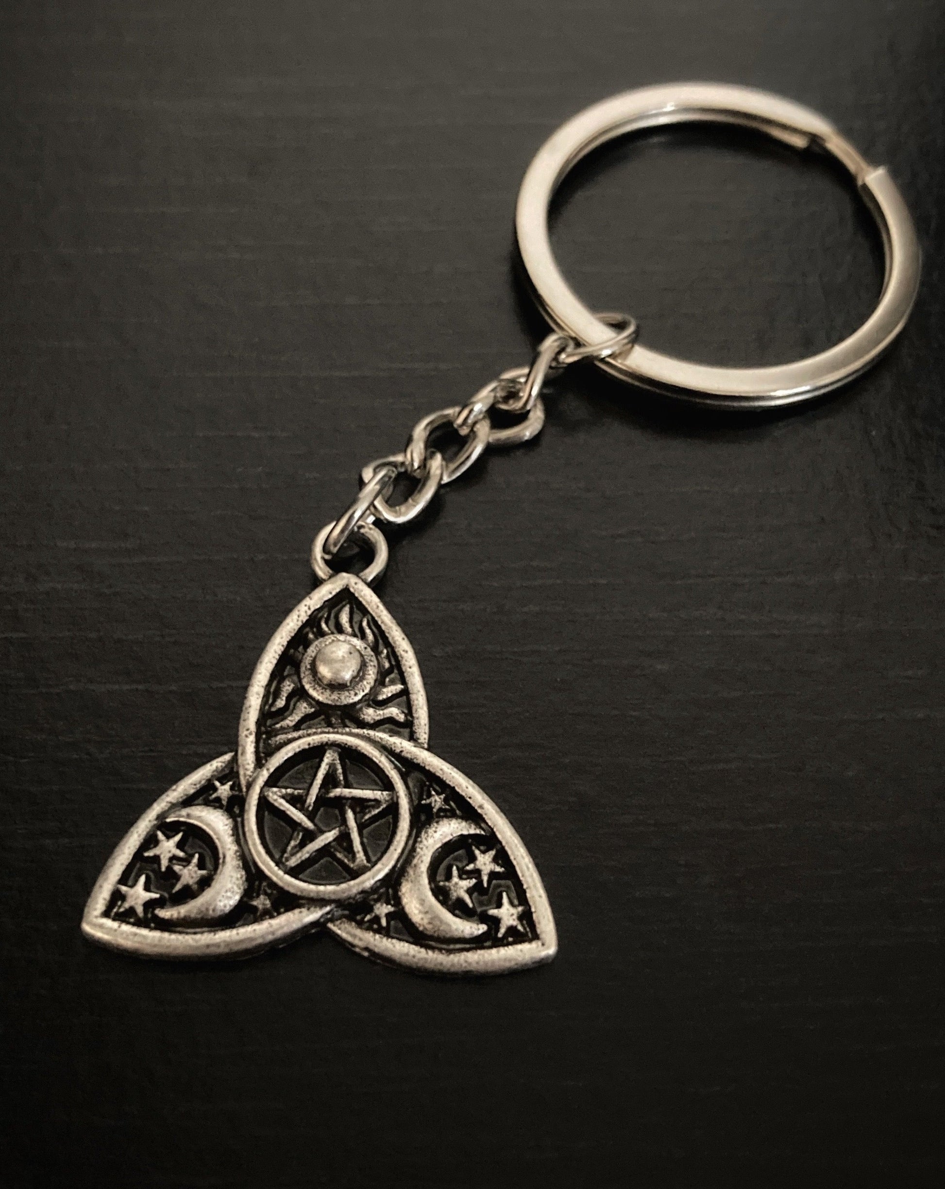 Intricate engravings of moons and stars are on a keyring which is silver in colour and more of a dull silver rather than shiny in appearance.