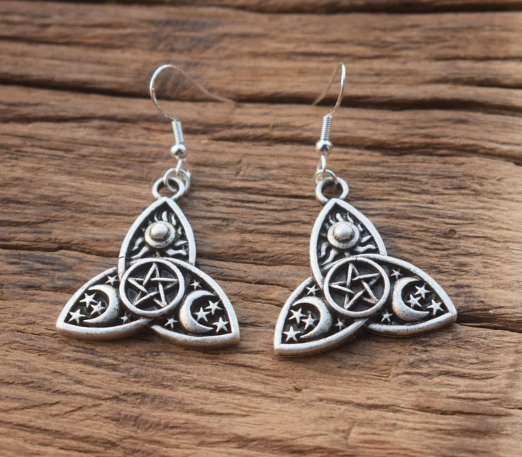 A pentagram design sits in a small circle in the middle of some earrings. Around this there are 3 shapes interlocked with moons and stars on them. These are more matt coloured than shiny and are lightweight to the touch.