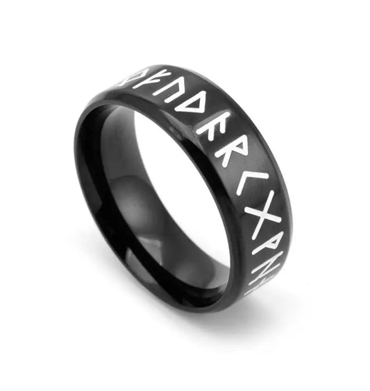 A black shiny ring sits on a white background. Around the outer part are white printed runic letters. The inner part of the ring is plain black.