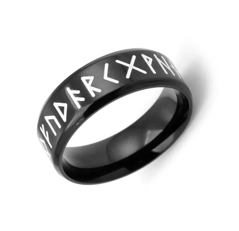 A ring sits at an angle on a white background. This item is black with white rune symbol letters surrounding the outer edge. This is lightweight to hold and wear and feels like real quality.